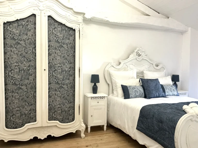 A large double bed and cupboard